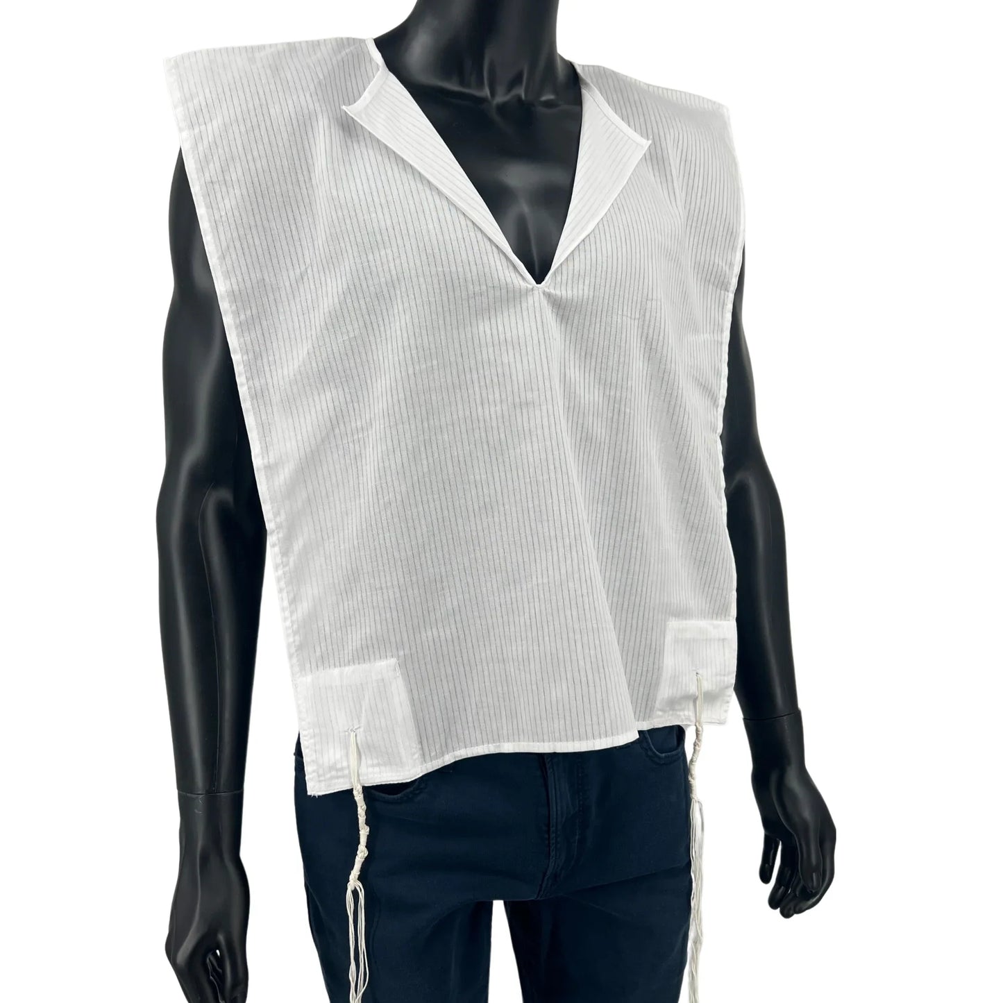 A white cotton Tallit Katan with vertical textured stripes, shown on a black mannequin torso. The garment features a V-shaped neckline and tzitzit strings hanging from the two front corners.