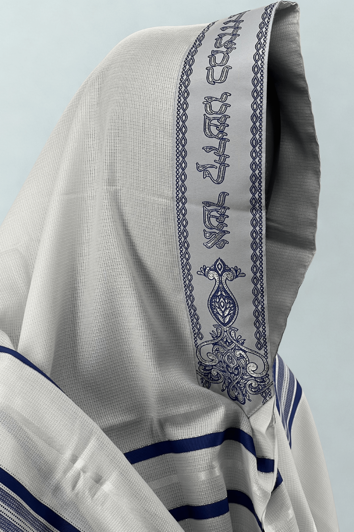 Close-up side view of a white Acrylic Tallit Chatanim with dark blue stripes and an embroidered atara (neckband)
