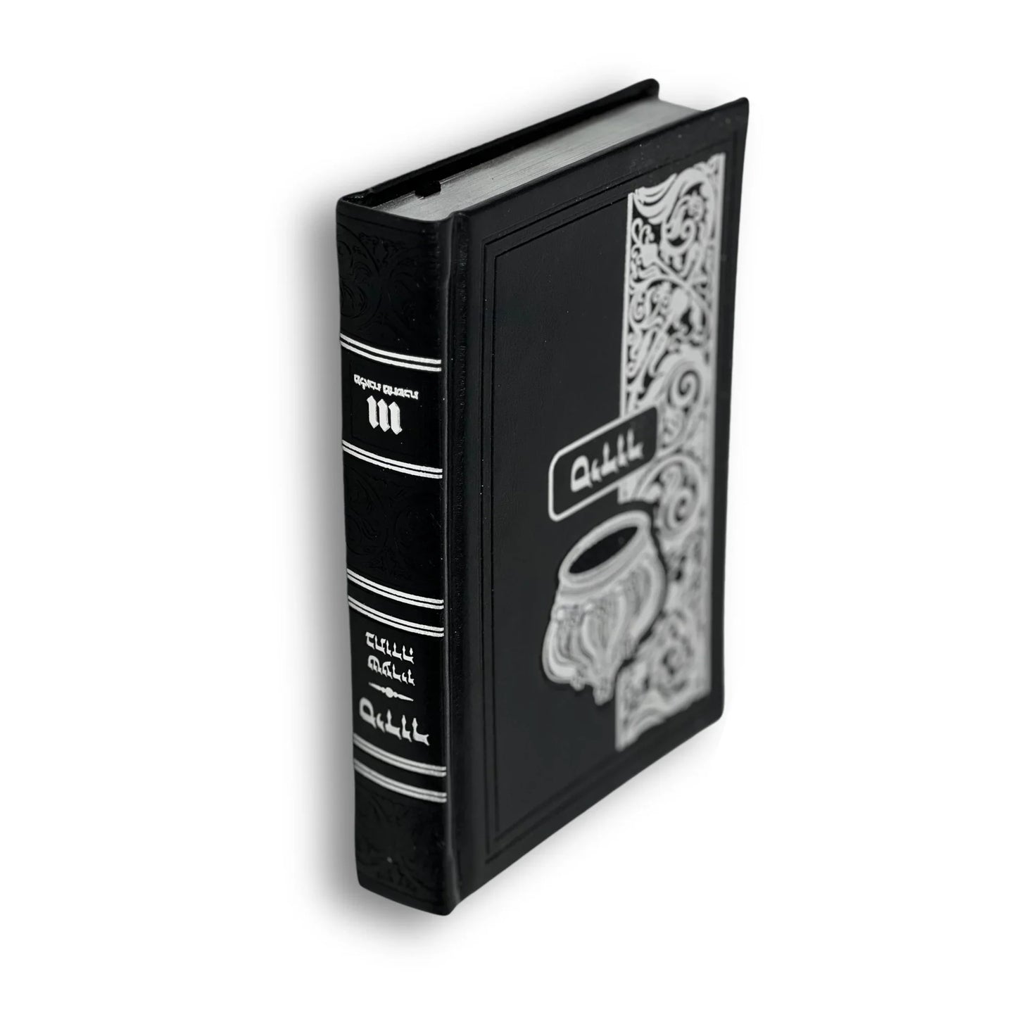 Black faux leather Tehillim (Book of Psalms) with silver embossed design, including an ornate cup and decorative floral border. The Hebrew and English word “Tehillim” appears on the front cover and spine. The book stands upright at a slight angle.