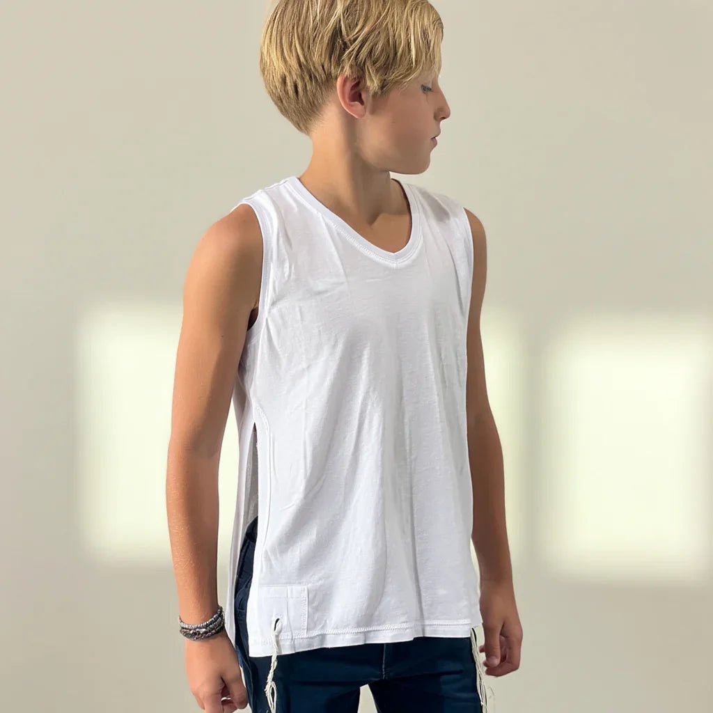 Boy wearing a white sleeveless Tzitzit T-shirt , side view, against a plain background