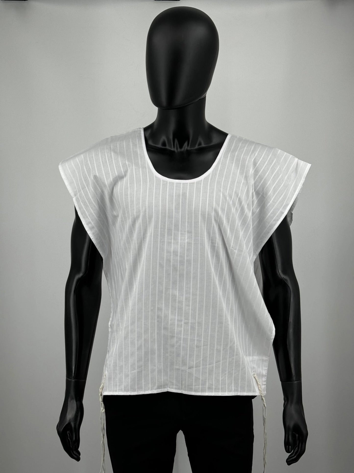 White sleeveless Tzitzit T-shirt on a black mannequin against a gray background