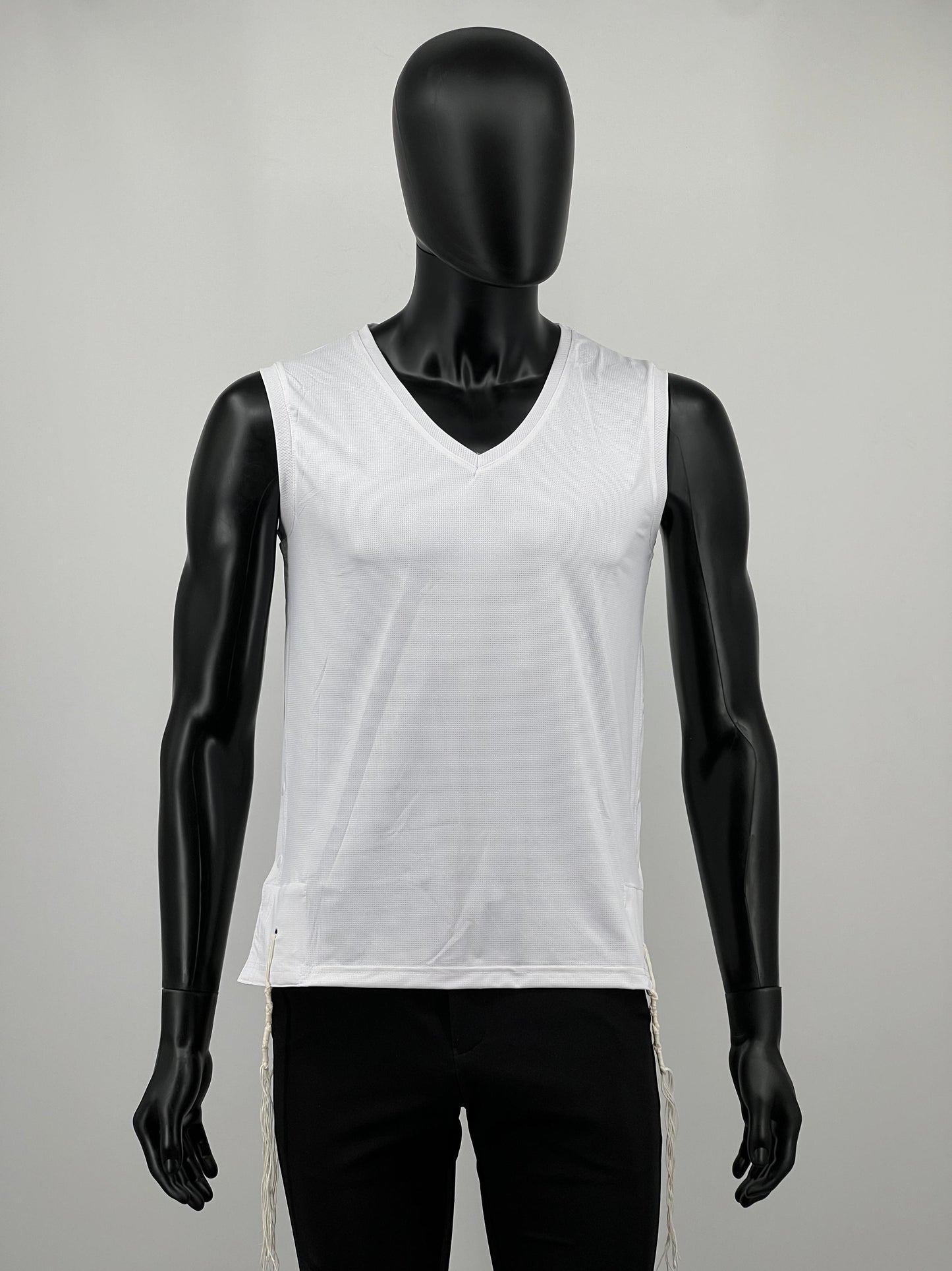 Mannequin wearing a white sleeveless tzitzit tank top on a gray background