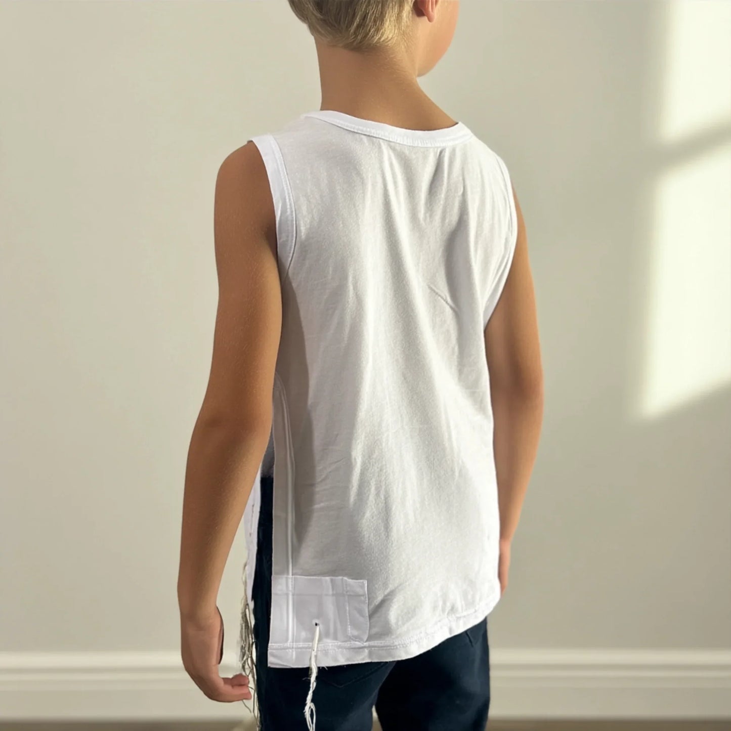Child wearing a white sleeveless Tzitzit T-shirt with a plain background