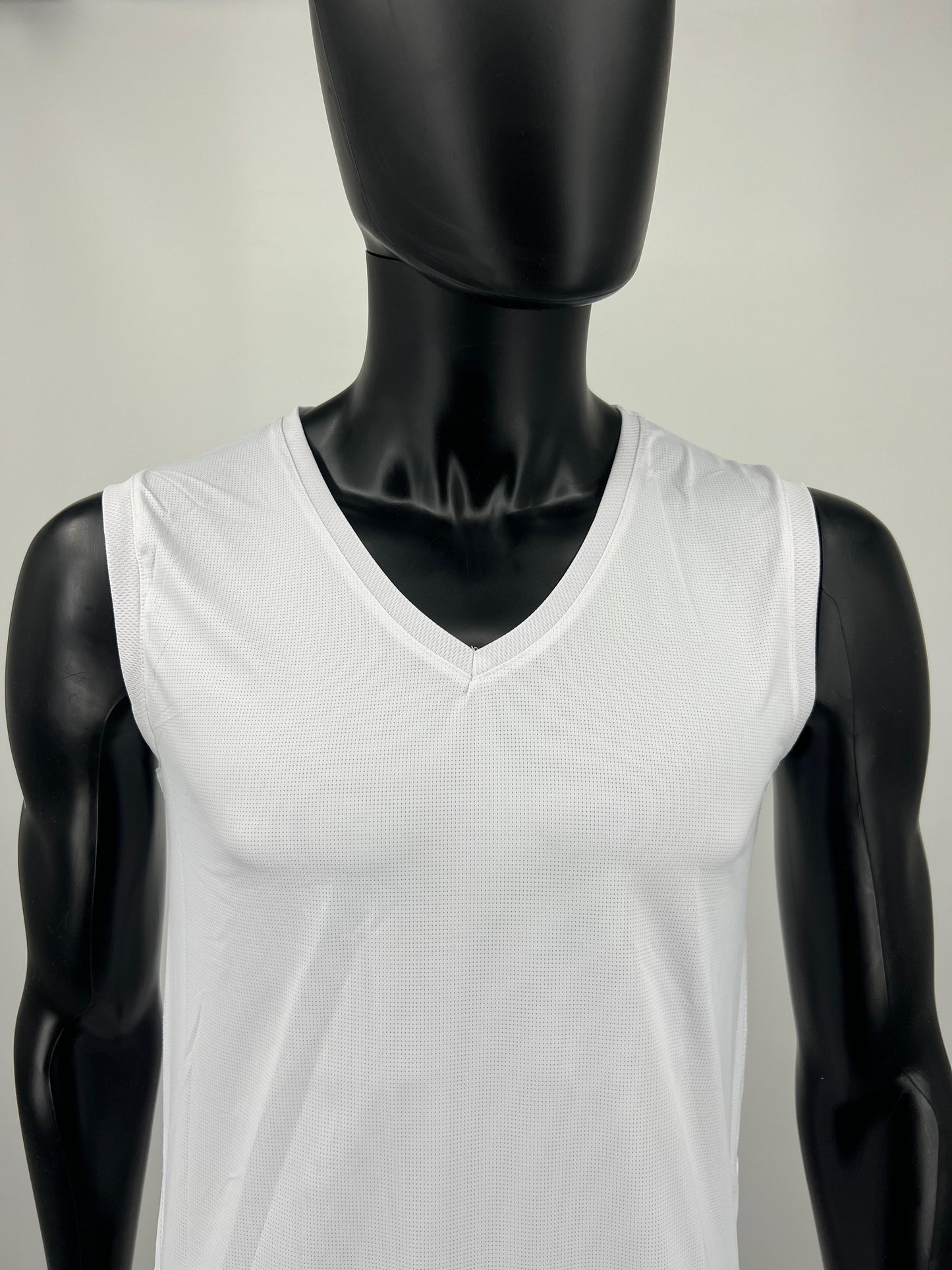 White sleeveless tzitzit tank top on a black mannequin against a plain background