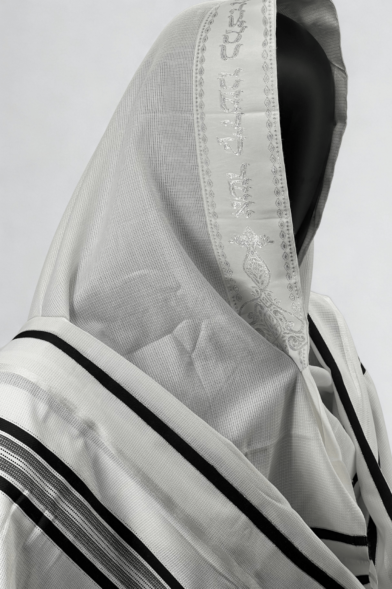 Close-up side view of a white Acrylic Tallit Chatanim with black stripes and an embroidered atara (neckband)