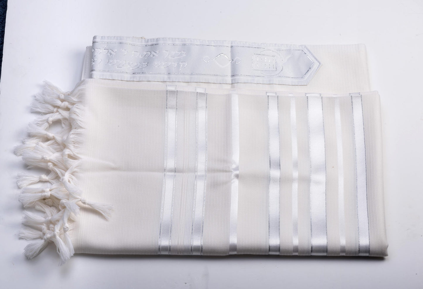White wool tallit katan with fringes on a white background
