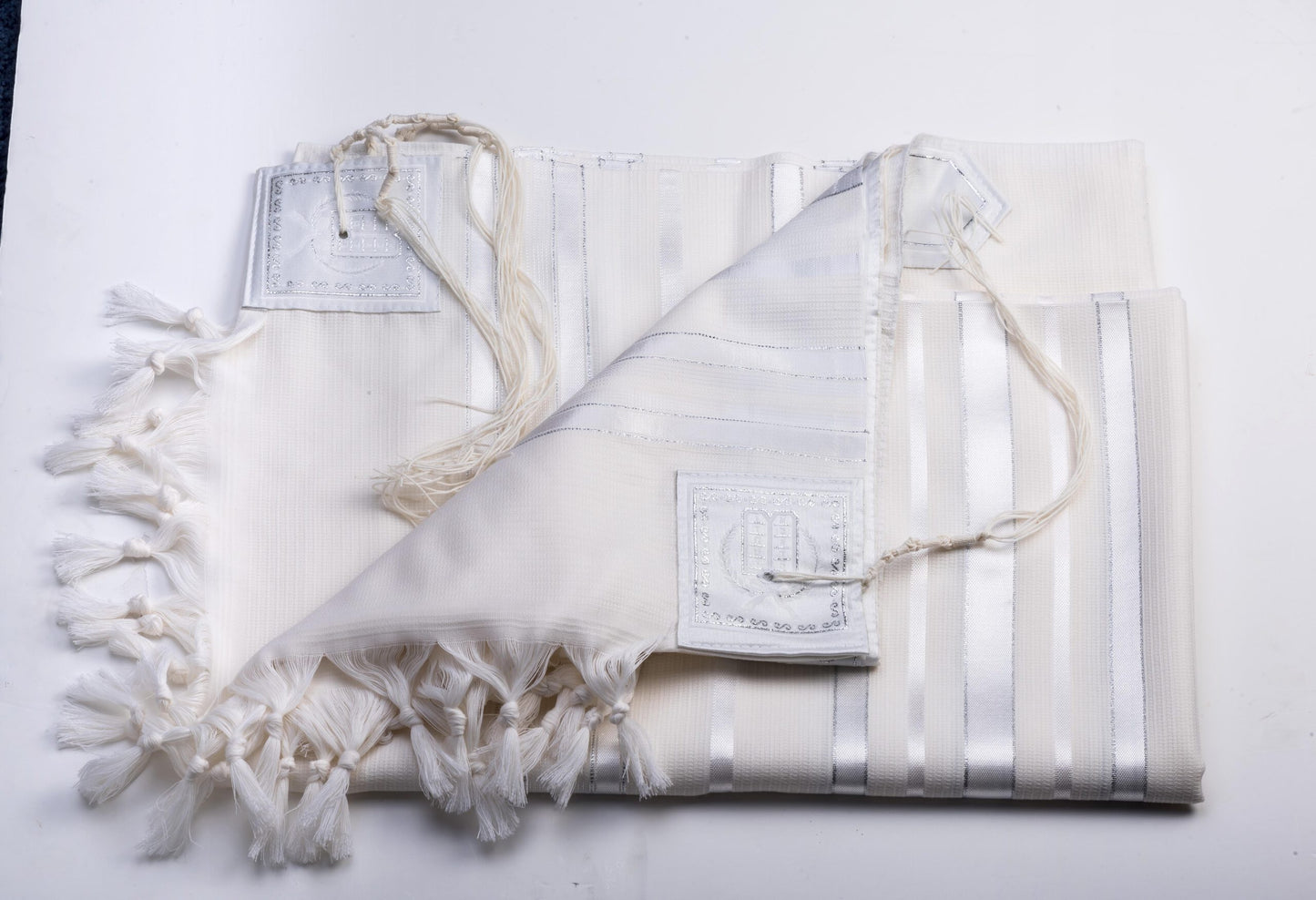 White prayer shawl with tassels on a white background