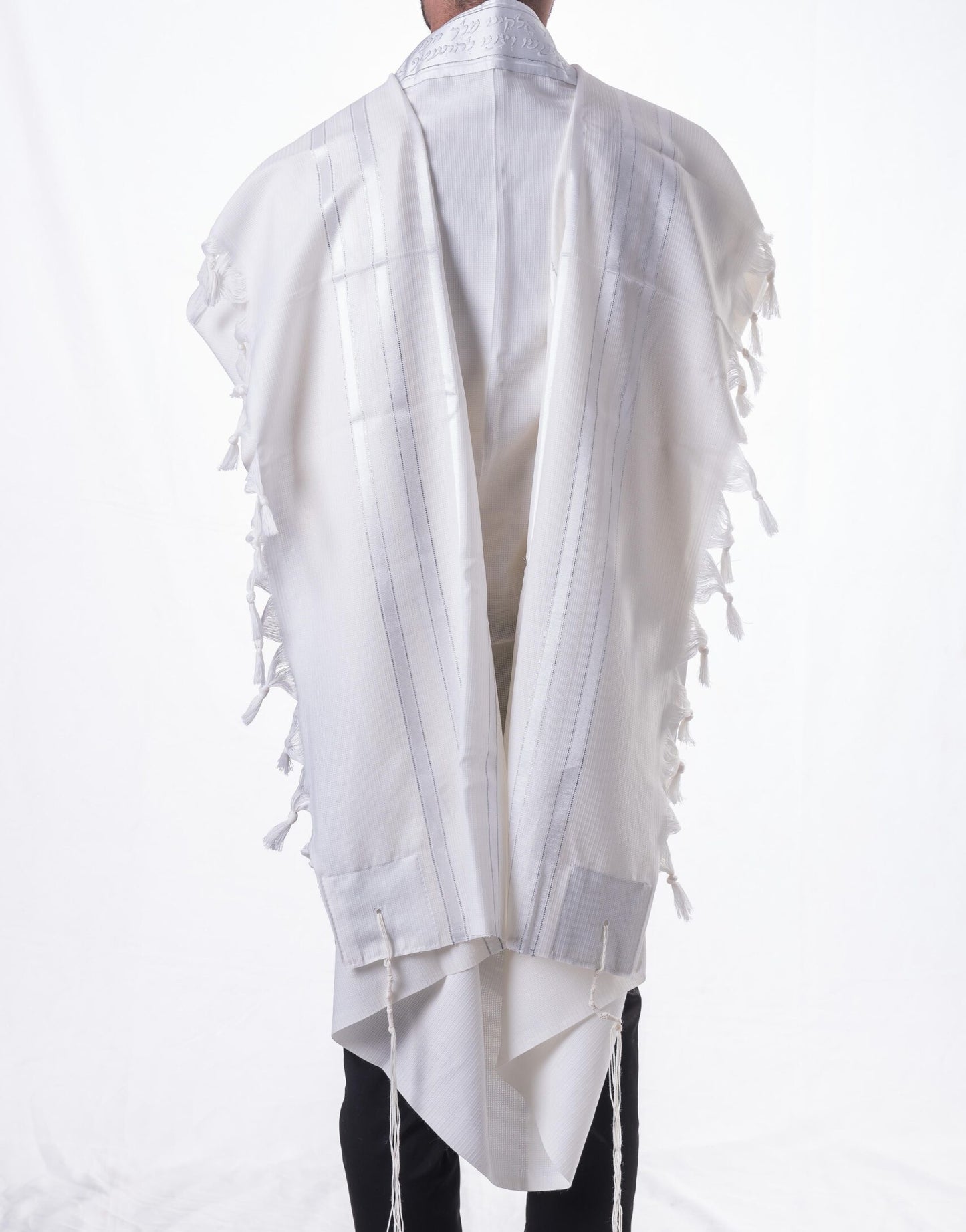 White prayer shawl with fringe details on a white background