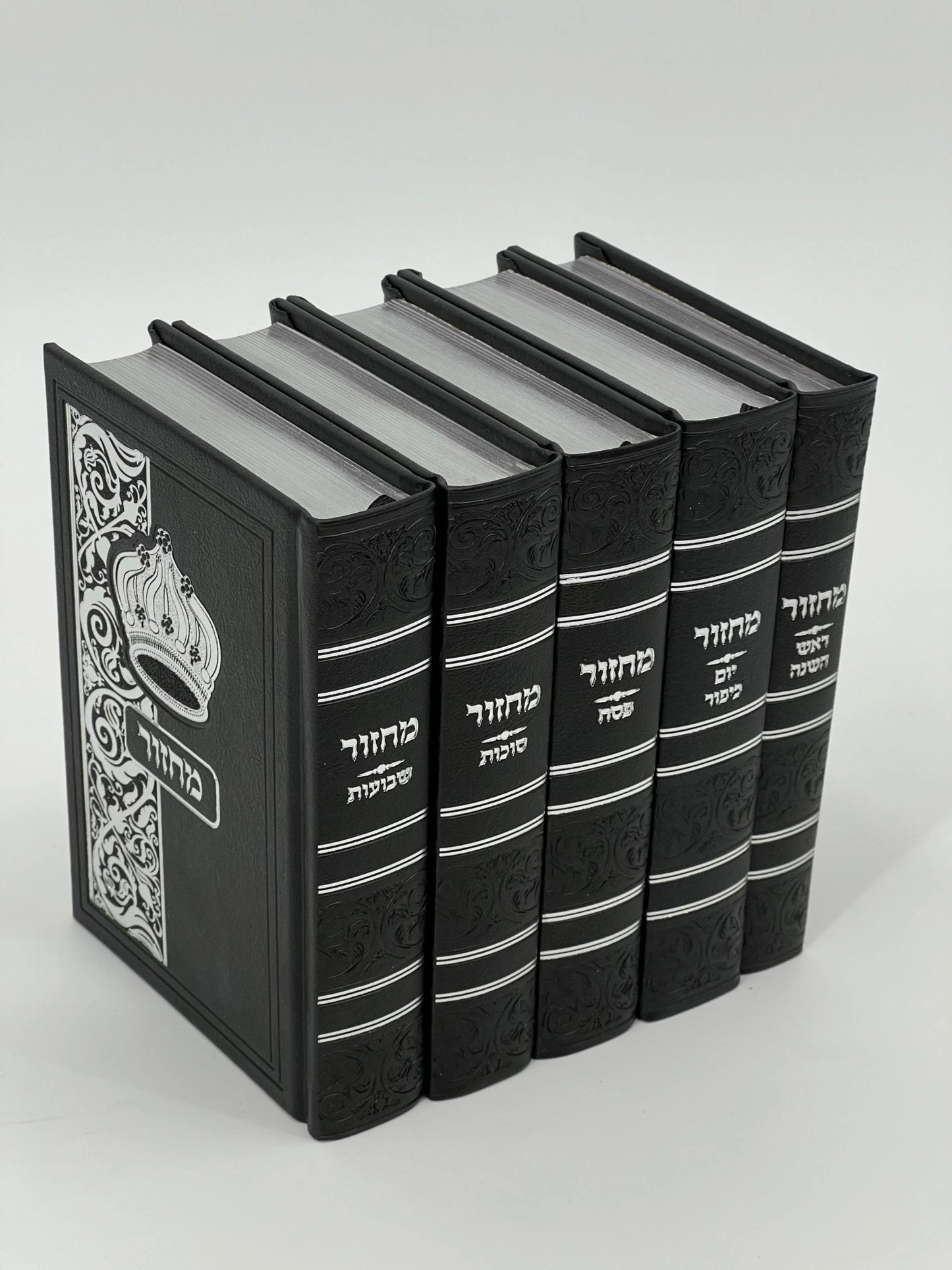Five-volume Sha'arav B'Todah Sephardi Machzor set in black faux leather with white embossed Hebrew text and crown design. Each volume features ornate decorative spines and includes prayers for Rosh Hashanah, Yom Kippur, Sukkot, Pesach, and Shavuot.