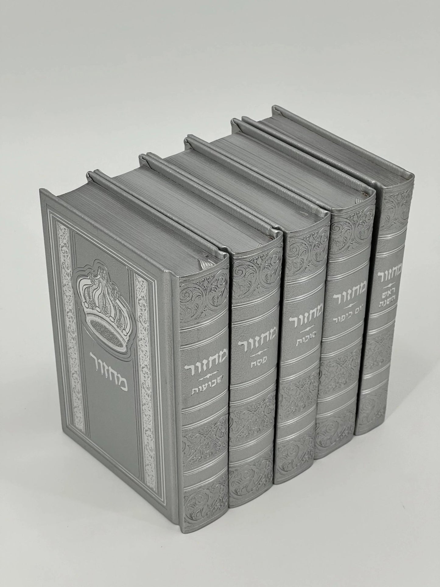 Five-volume Sha'arav B'Todah Sephardi Machzor set in silver-gray faux leather. Each volume features ornate embossed detailing, Hebrew titles, and a crown design on the front cover. The set includes Machzorim for Rosh Hashanah, Yom Kippur, Sukkot, Pesach, and Shavuot.