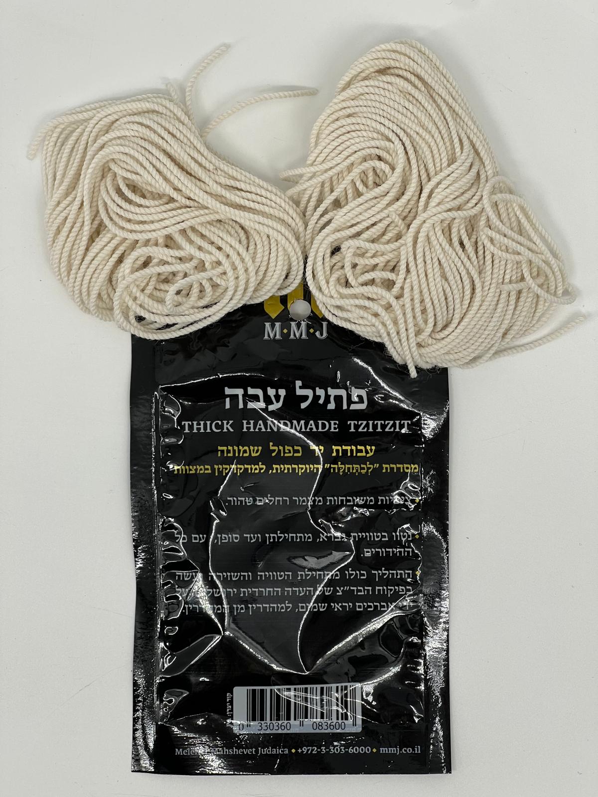 Set of thick handmade wool tzitzit strings displayed above black packaging with Hebrew and English text.