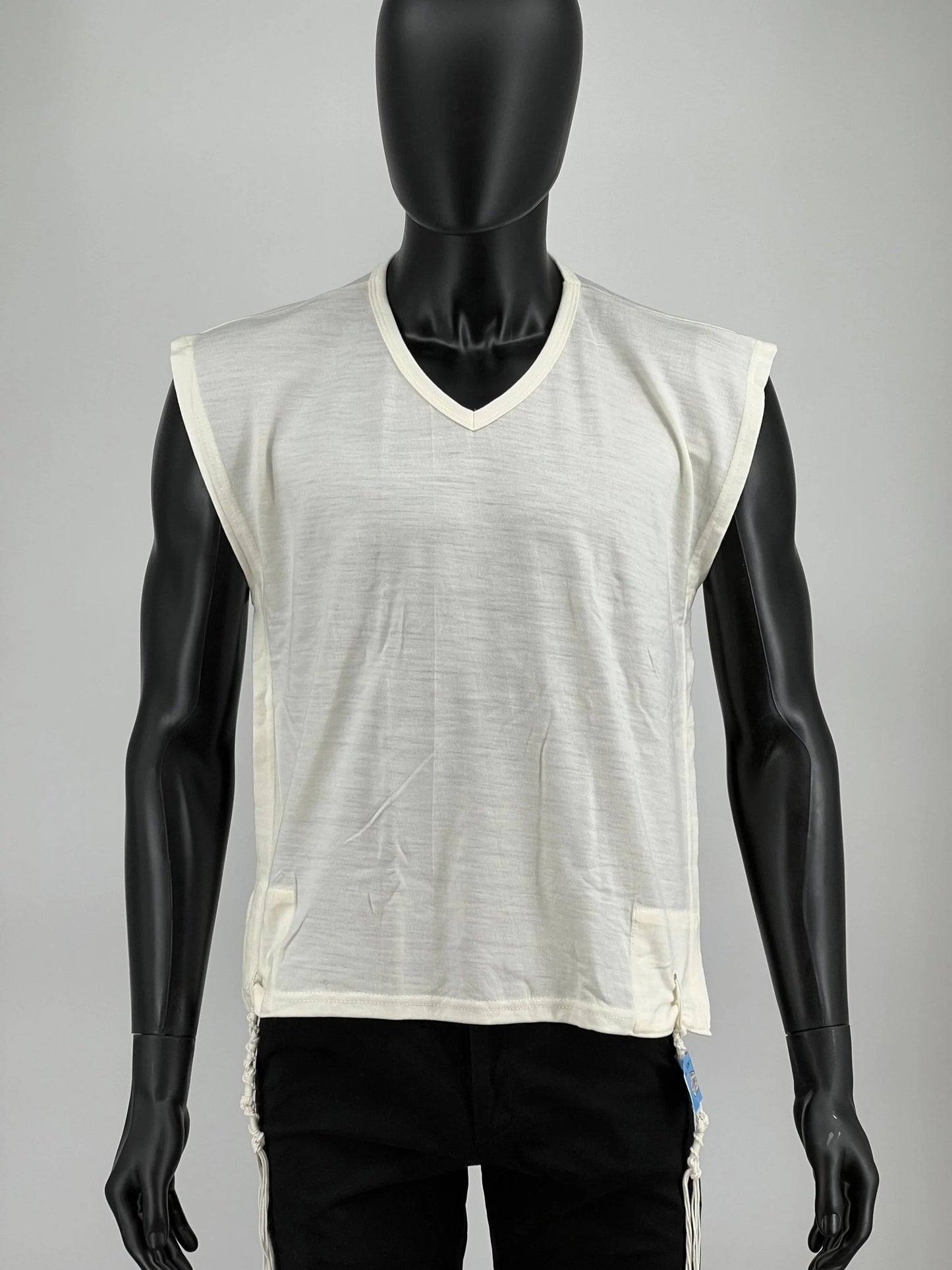 White wool Tzitzit T-shirt vest displayed on a mannequin torso. Made from 100% lamb’s wool, the garment features a wide halachic V-neck opening, front view