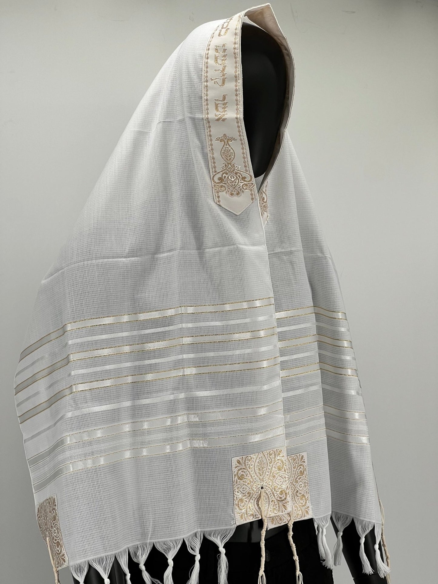 A tallit scarf with gold and white stripes and silver accents, displayed on a white background.