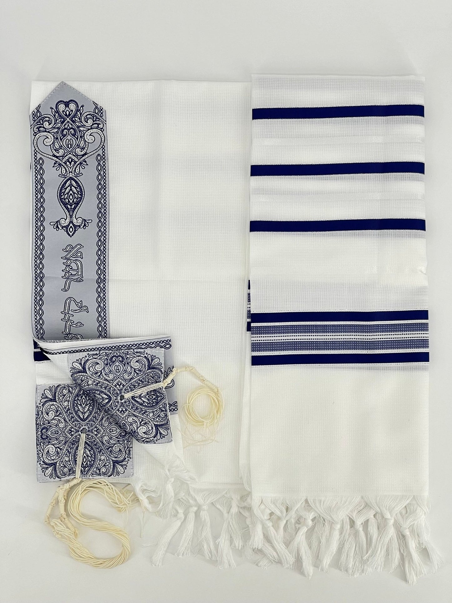Flat-lay image of a white Acrylic Tallit Chatanim with blue stripes and silver decorative elements.
