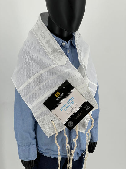 Child mannequin wearing a white children's tallit (Jewish prayer shawl) with silver stripes and embroidered corners, atara