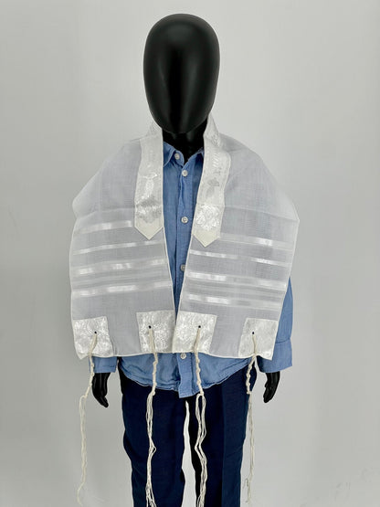 Child mannequin wearing a white children's tallit (Jewish prayer shawl) with white stripes and  white embroidered corners