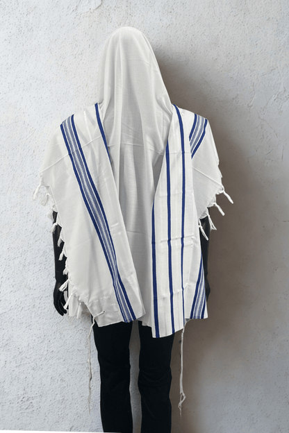 mannequin dressed in a white Acrylic Tallit Chatanim with blue stripes, worn over a black outfit.