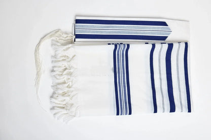 A white tallit with blue and white stripes, featuring a fringed edge and a tassel at the corner.