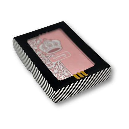 Pink faux leather Siddur with silver embossed crown design, displayed in a black-and-white striped gift box with a clear window. Hebrew word "סידור" appears on the cover. The box features a gold "MMJ" logo at the bottom.