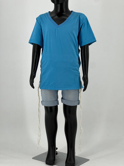 Full-body view of a child-sized mannequin wearing a bright blue V-neck short-sleeve Tzitzit T-shirt paired with light blue rolled-up denim shorts. White Tzitzit fringes hang from the four corners of the garment in accordance with traditional Jewish practice. Displayed against a plain light background.