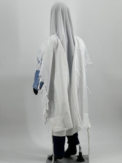 Child mannequin dressed in a white tallit (Jewish prayer shawl) viewed from a rear side angle.
