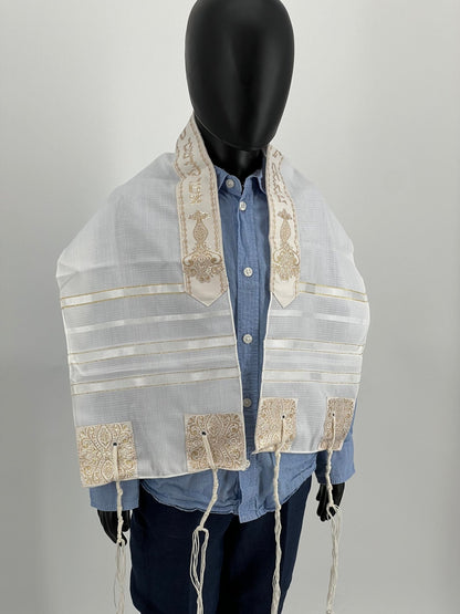 Child mannequin wearing a white children's  prayer shawl with gold stripes and decorative gold embroidered corners