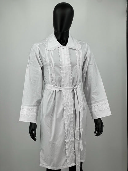 White kittel with lace details on a mannequin against a plain background.