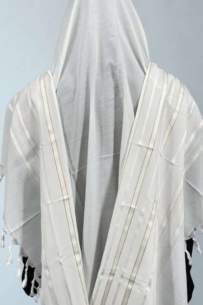 White prayer shawl with fringe details on a light blue background