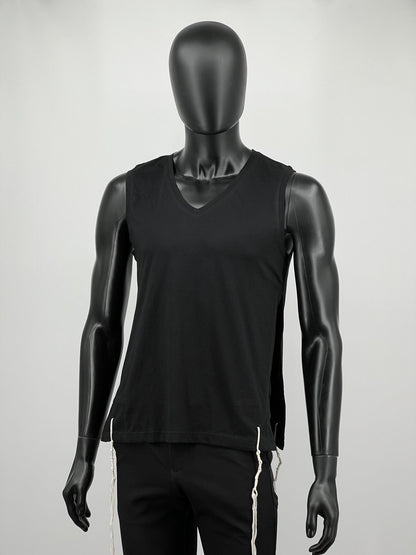Full-body view of a mannequin wearing a black sleeveless V-neck Tzitzit T-shirt vest paired with black pants. White Tzitzit fringes hang from all four corners of the garment, in accordance with traditional Jewish practice. Displayed against a plain light background.