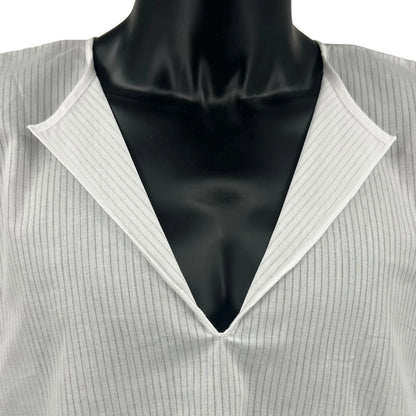 Close-up front view of a white cotton Tallit Katan worn on a black mannequin torso. The garment features a V-neck opening, fine vertical stripes