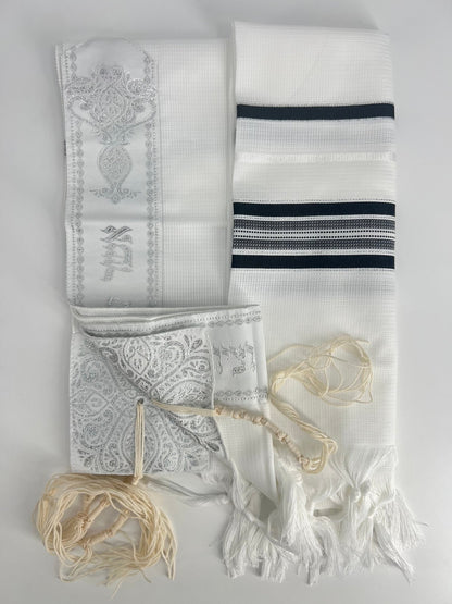 children's tallit with acrylic tashbetz  laid out on a white background.