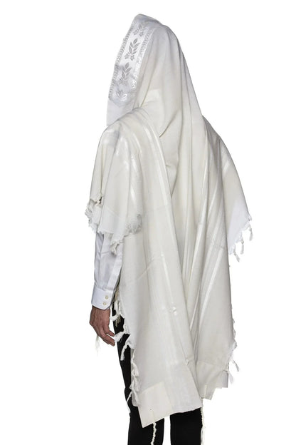 Man wearing a traditional white wool Tallit, draped over his head and shoulders during prayer.