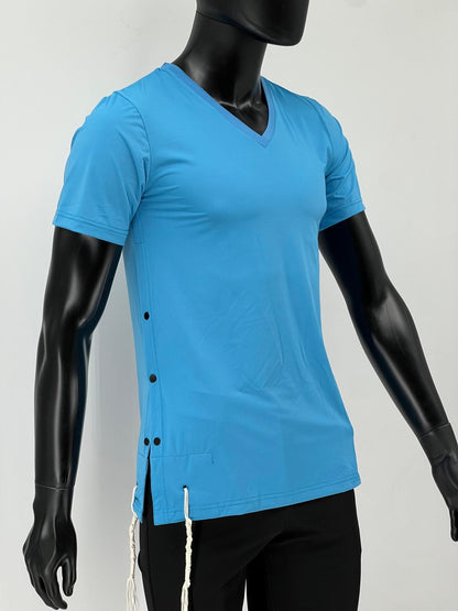 Side view of a mannequin wearing a bright blue V-neck short-sleeve Tzitzit T-shirt with black side buttons and white Tzitzit fringes hanging from the hem. The shirt is made of breathable fabric and is paired with black pants. Displayed against a plain light background.