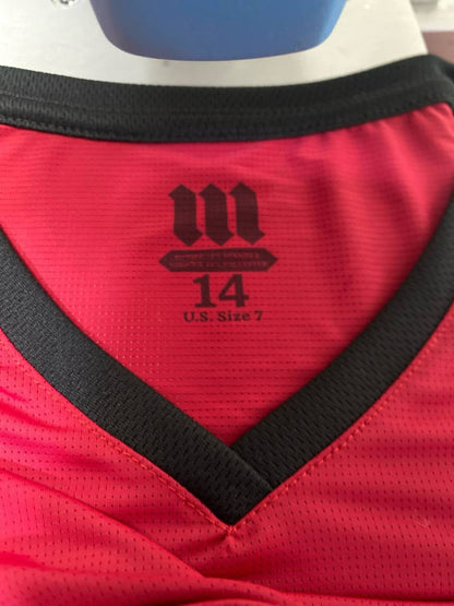 Close-up image of the inside collar of a red athletic Tzitzit T-shirt with a black V-neck trim. The label printed on the fabric includes the MMJ Judaica logo