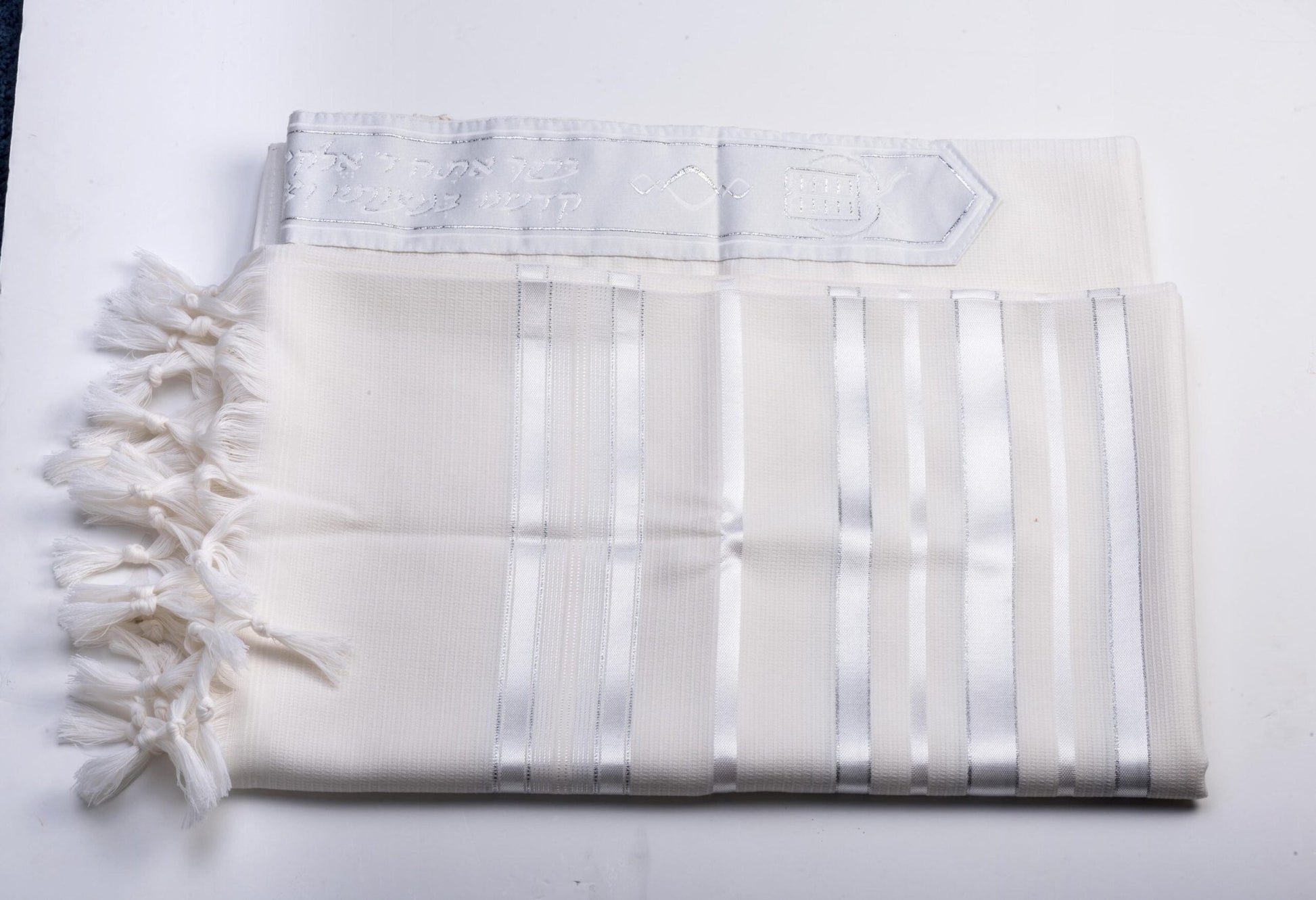 White wool tallit katan with fringes on a white background