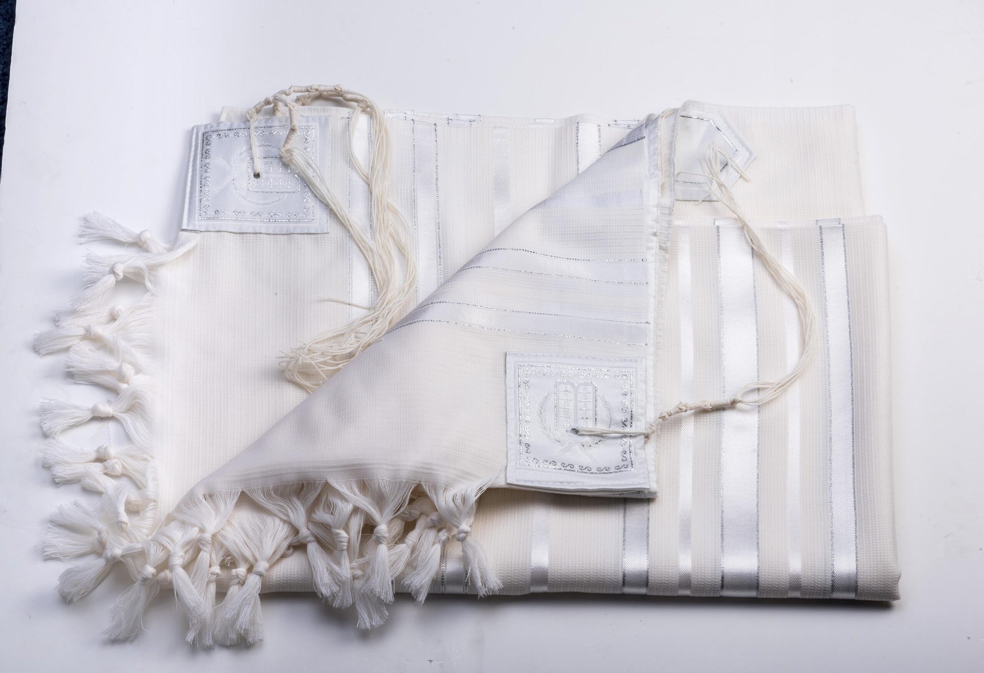 White prayer shawl with tassels on a white background