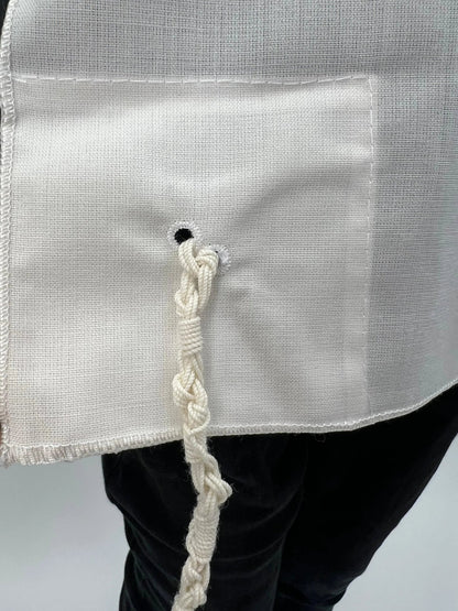 Close-up of a corner of a white wool Chabad Tallit Katan tzitzit