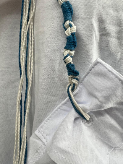 Close-up of a white Tzitzit T-shirt with a reinforced corner pocket showing tied Tzitzit string - blue Ptil Tekhelet