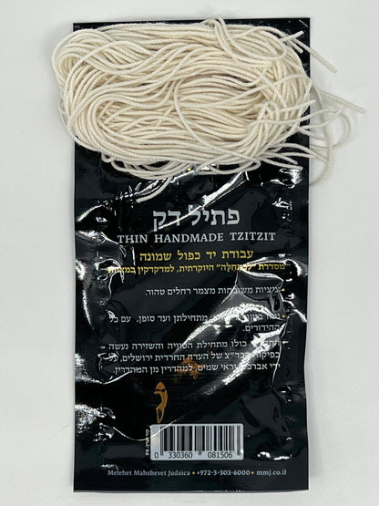 Bundle of thin handmade wool tzitzit strings resting on black packaging with Hebrew and English text.