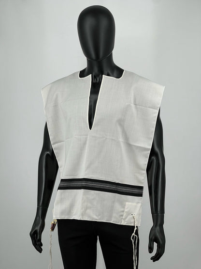 Mannequin wearing a Ashkenazi tallit katan with a cutout design on a gray background