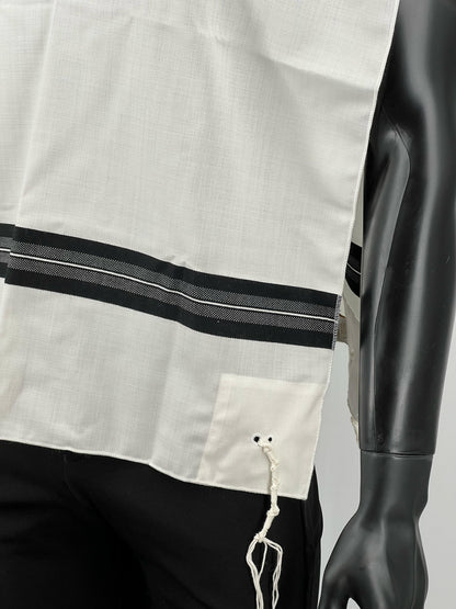 Close-up of white wool Tallit Katan with black striping and decorative fringe along the bottom on a mannequin.
