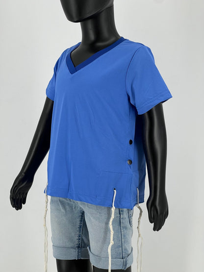 Mannequin dressed in a blue V-neck short-sleeve Tzitzit T-shirt with black side buttons and white fringes (Tzitzit) hanging from the garment’s corners, paired with light blue denim shorts. The outfit follows traditional Jewish customs and is displayed against a plain light background.