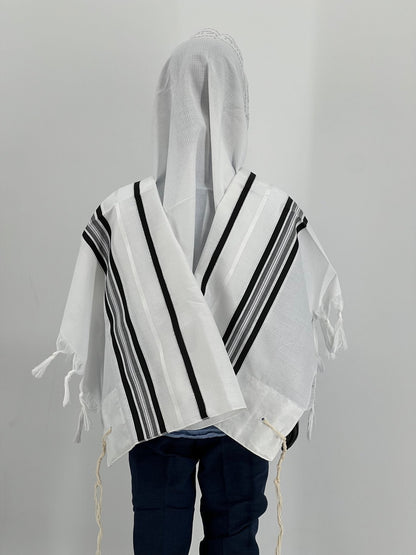 A child wearing a white and black striped tallit (prayer shawl).