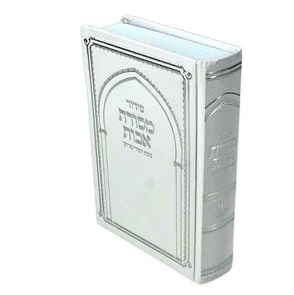 A silver Siddur with decorative text on the cover, indicating it is a Jewish prayer book.