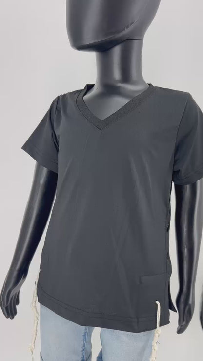 Video of a black V-neck short-sleeve Tzitzit T-shirt paired with light blue denim shorts. White Tzitzit fringes are hanging from the four corners of the garment, representing traditional Jewish religious practice. Displayed against a plain light background.